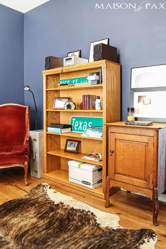 deep navy blue office with rustic wood floors, lots of bookcases, and an eclectic, collected vibe