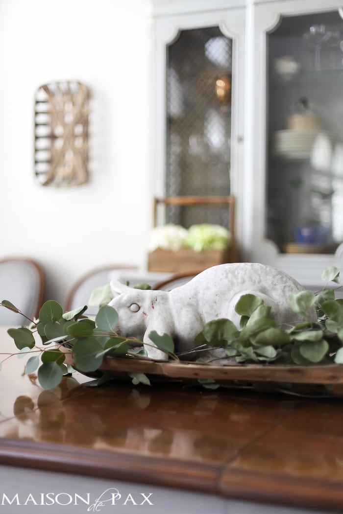 What a cute, simple idea for Easter decor! Use a garden statue bunny in a basket with dried greens as a centerpiece for your table | maisondepax.com